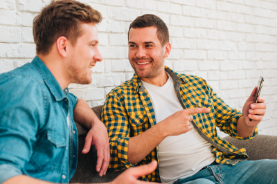 Dos creadores de contenido conversando y riendo, representando cómo los influencers pueden ayudar a promocionar productos sin costo.